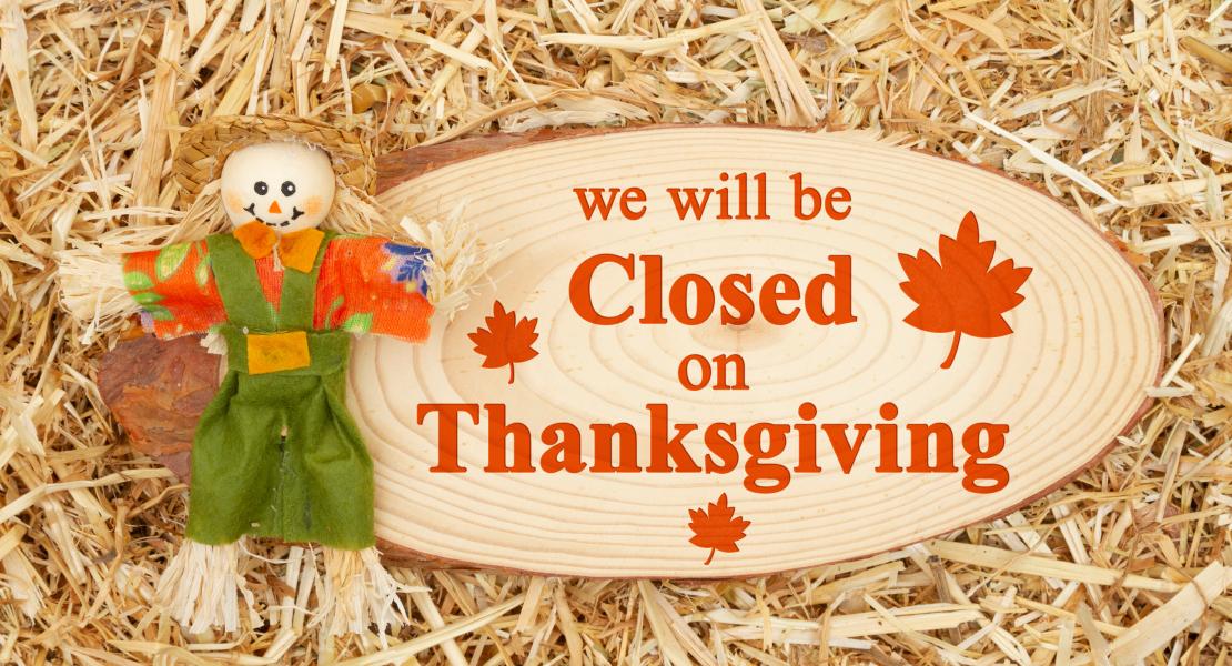 Scarecrow next to sign that reads Closed for Thanksgiving