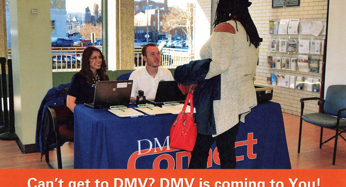 Woman wearing hat standing in front of two seated DMV Connect helpers.